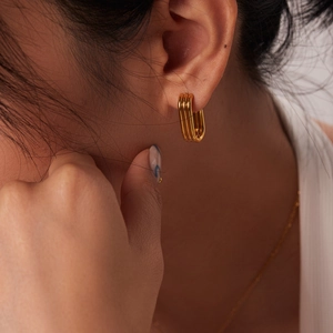 Détail des boucles d'oreilles en acier inoxydable doré 18K à triple couche sur modèle