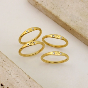 Detailed macro view of 18K gold plated stainless steel zodiac rings with crystal insets