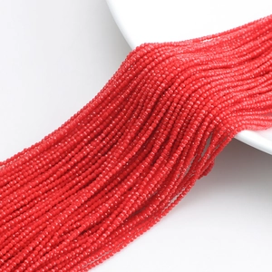Close-up of red faceted crystal glass beads strings displayed on a white plate