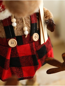 Close-up of reindeer plush in buffalo plaid overalls with rustic wooden button details