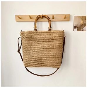 Macro shot of natural woven texture with bamboo handles and leather strap of beach bag
