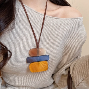 Detailed macro of vintage acrylic geometric square pendant on knit sweater style