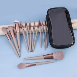 Macro shot of 13 professional makeup brushes with rose gold ferrules and portable bag