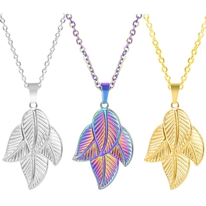Detailed view of three leaf pendants in silver, gold, and multicolor 18k plated steel