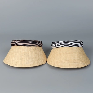Close-up of woven straw sun hats featuring zebra and tiger print elastic headbands