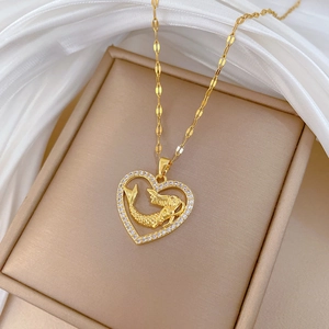 Detail shot of golden heart mermaid pendant with crystals in a jewelry box
