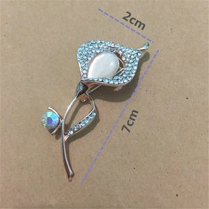 Macro detail of rose gold floral brooch with blue crystals and cat eye stone inlay