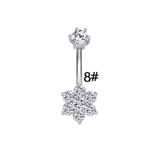 Macro shot of silver navel ring with flower-shaped zircon petals and stainless steel curved bar