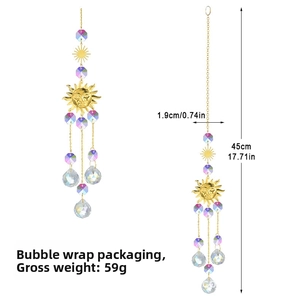 Detailed view of solar suncatcher with golden sun motif and crystal ball pendant prism