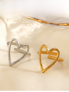 Macro detail of textured gold and silver heart rings with a hammered metal finish