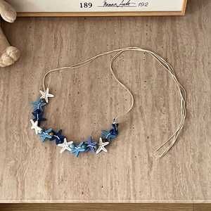 Bohemian multilayer necklace featuring blue and white starfish pendants and gold beads