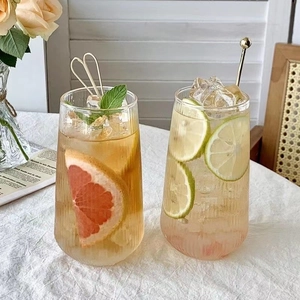 Vertical ribbed glass cups for coffee and juice with lime slices and ice cubes