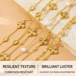 Detail of layered gold stainless steel bracelets with diamond clover and pearls