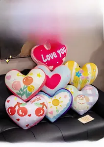 Detailed view of colorful heart-shaped plush pillows with various cute patterns on sofa