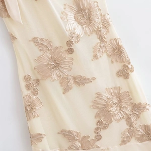 Vue détaillée de la broderie florale crème sur tissu en maille transparente pour robes