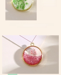 Detailed view of handmade resin pendants with real dried flowers and alloy frames