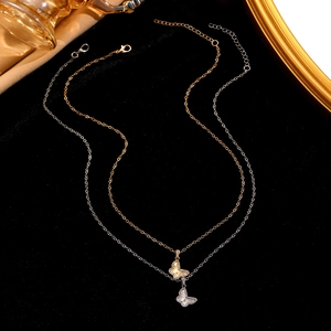 Detailansicht der Schmetterlingsanhänger in Gold und Silber mit feinen Texturen am Schmuck