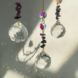 Macro shot of faceted crystal balls and purple crushed stones with rainbow light effects