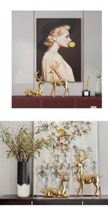 Detail of luxury gold elk statues with a polished mirror finish on dark wood furniture