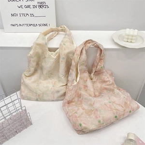 Detalle de bolsos tote de malla con bordado de lazos delicados y texturas suaves en tonos pastel