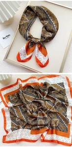 Detail showing paisley silk-feel square scarf with orange borders and geometric patterns