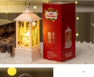 Close-up of a white Christmas LED lantern with snowman scene and its red retail packaging