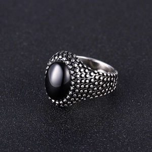 Detailed close-up of retro silver stainless steel ring with oval black stone inlay