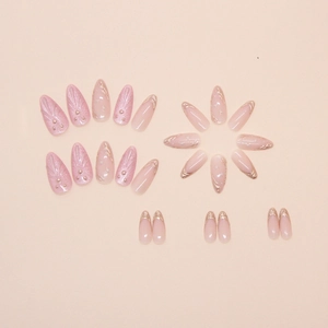 Detail of pink almond press-on nails with 3D shells, pearls and gold French lines