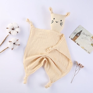 Detail of baby organic cotton muslin security blanket with cute cat head and knotted corners