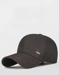 Detail of a dark brown baseball cap featuring a metallic Sport logo on fine twill fabric