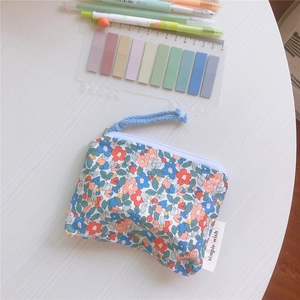 Detail of cotton floral coin purse with zipper closure and simple wish woven label