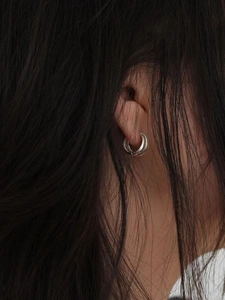 Close-up of 925 sterling silver triple hoop earrings worn by a model with dark hair