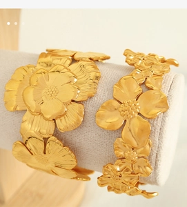 Detailed close-up of matte gold camellia bracelets on a jewelry roll display