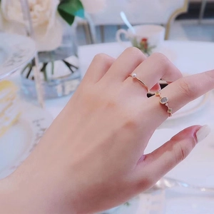 Close-up of stacked gold rings with elegant pearl and colorful gemstone accents