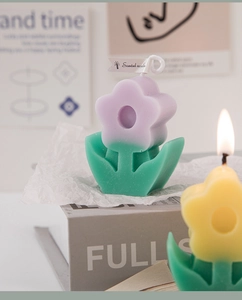 Macro shot of purple and green flower-shaped scented candle with decorative leaf base