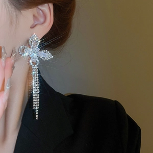 Close-up of butterfly zircon earrings with long tassels on a model for a stylish look