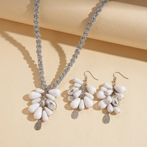 Chic silver necklace and earrings set featuring white acrylic teardrop charms on beige base