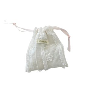 White striped fabric drawstring bag with lace trim and pink satin ribbon for storage