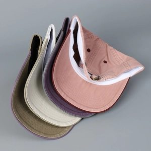 Detail of stacked washed cotton baseball caps with adjustable metal buckles in multiple colors