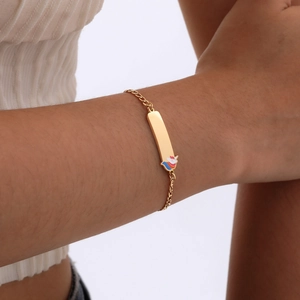 Golden ID bracelet for girls featuring a colorful enamel unicorn charm and engravable plate