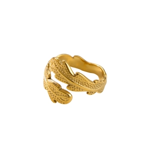 Detailed macro view of the golden feather-shaped metal ring with delicate textures