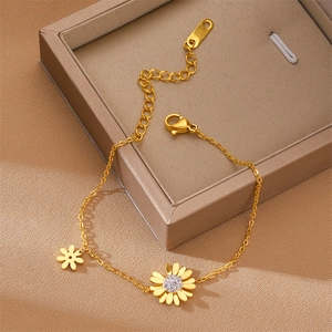 Elegant gold titanium daisy bracelet with cubic zirconia accents on a jewelry box