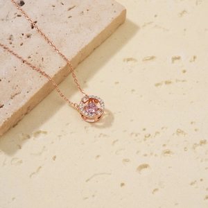 Rose gold necklace with a pink dancing heart pendant and white cubic zirconia on stone