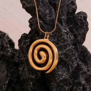 Close-up of a 18K gold plated spiral pendant necklace on a textured black rock background