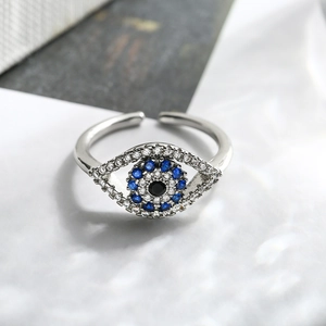 Macro detail of silver evil eye adjustable ring featuring blue and white zircon pavé