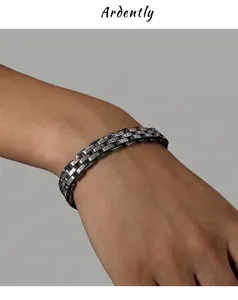 Close-up of retro titanium steel bracelet with engraved Roman numeral link texture