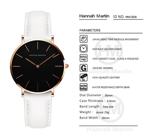 Close-up of minimalist rose gold watch with black dial and white leather strap