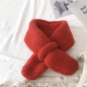 Detail of red knit baby scarf with soft ribbed texture and easy cross-loop design