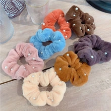 Close-up of colorful plush scrunchies with elegant white pearl bead accents