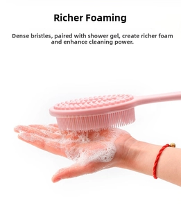 Close-up of pink silicone bath brush generating rich foam for effective skin cleaning